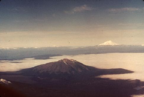 Stratus cloud deck, seen from above. Stratovolcanoes seen in foreground and background.