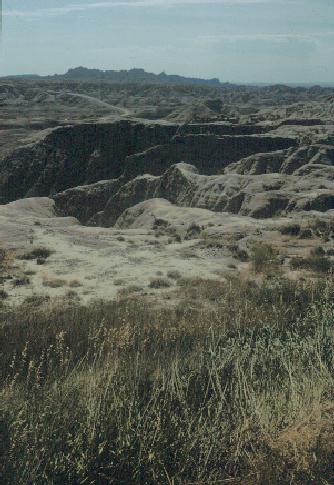 Badlands. Start of erosion beyond grassy part. Eventually erosion will cut back into top surface with grassy part.